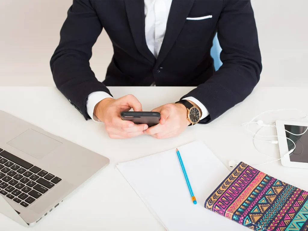 Businessman using a smartphone to research how to find the right strata manager.
